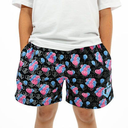 Youth model wearing blue youth shorts with "10 Year Anniversary" design