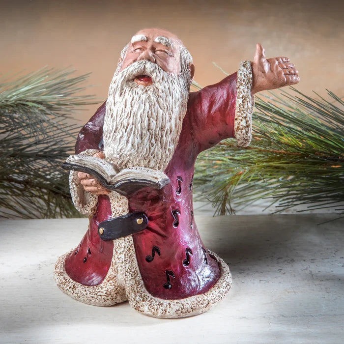 Decorative figurine of a bearded man in red robes with a book, against a neutral background.
